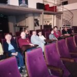 Grupa osób (mężczyźni i kobiety) siedząca na sali kinowej